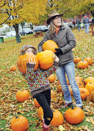 Kira Walker-vanAalst, left, and Indy Ewald find gourds they like.