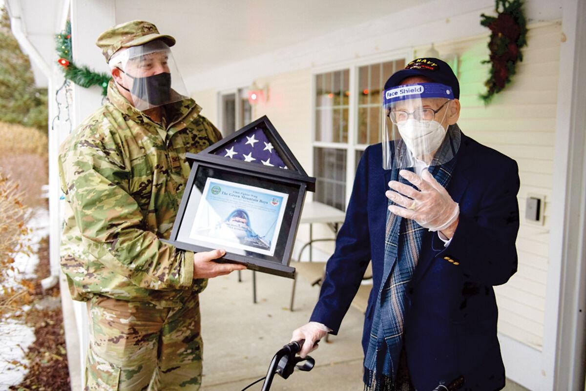 Col. Adam Rice presents a flag to Lenny Roberge