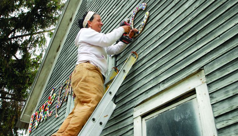 Thea Alvin installing gallery sign
