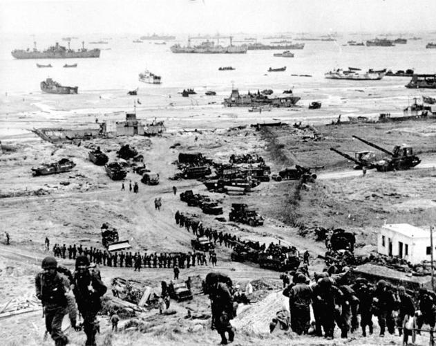 American troops move inland after securing Omaha Beach on D-Day, June 6, 1944.