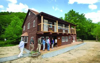 Visitors tour the Barnes Camp Visitors Center during a ceremony and open house at the base of Smugglers’ Notch