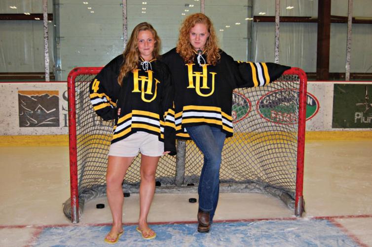 Harwood seniors Katie Martin (left) and Siena Damon, who have been playing hockey together for 13 years, pose in front of the net.
