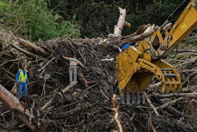 Search and recovery crews use a large excavator to remove debris from the bank of the Guadalupe River on July 9, 2025, in Center Point, Texas.