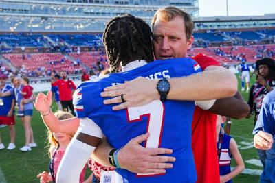 SMU head coach Rhett Lashlee hugs quarterback Kevin Jennings after the Mustangs' 31-18 victory over Syracuse in an NCAA football game on Saturday, Oct. 4, 2025, in Dallas.
