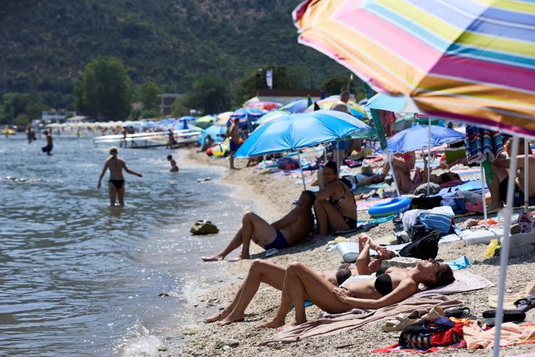 Tourists and residents brave the heat to enjoy the beach