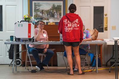 Poll workers listen to a voter at Meridian Baptist Church at 6513 Chapman Highway during the first day of Early Voting in