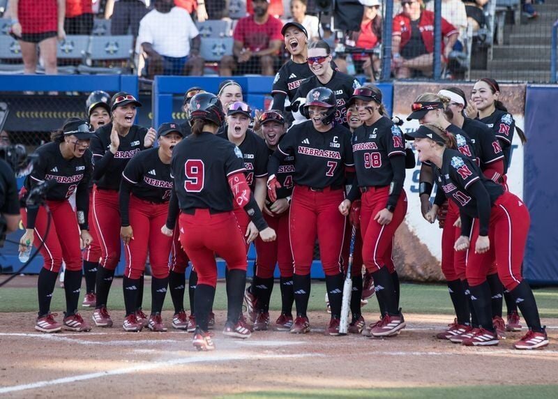 May 30, 2026; Oklahoma City, OK, USA; Nebraska Cornhuskers players wait at home plate for utility Hannah Camenzind (9) after she hit a solo home run in the fourth inning against the Alabama Crimson Tide during the NCAA WomenÕs College World Series at De...