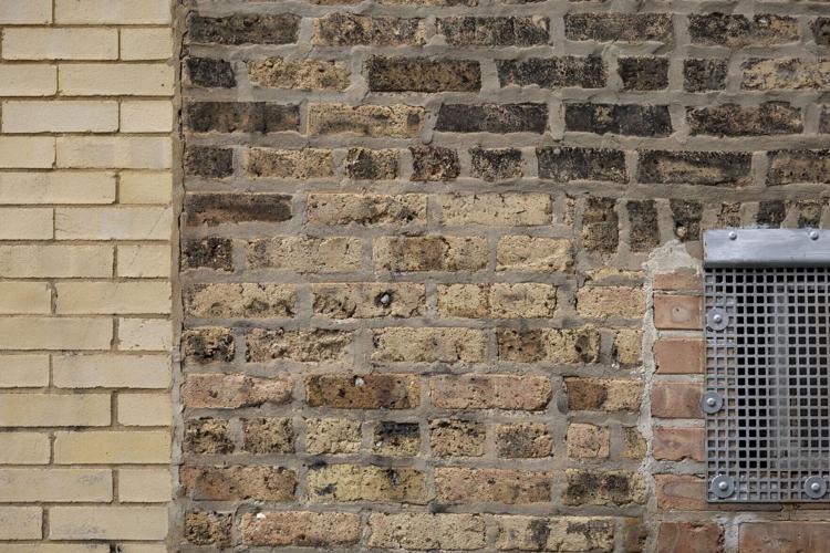 Will Quam talks about Chicago common brick next to face brick in an alley while leading one of his neighborhood tours Sunday, April 19, 2026, in Albany Park.