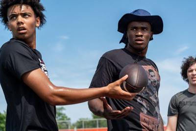 Trae Taylor, 16, left, a quarterback at Carmel Catholic High School and a Nebraska commit in the class of 2027, gives the ball to Bryce Underwood, 17, a freshman quarterback at the University of Michigan, during a private workout in Detroit on Saturday,...