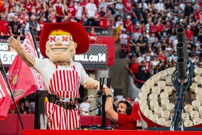 Sep 7, 2024; Lincoln, Nebraska, USA; Herbie Husker shoots shirts into the crowd between the first and second quarter against the Colorado Buffaloes at Memorial Stadium. Mandatory Credit: Dylan Widger-Imagn Images