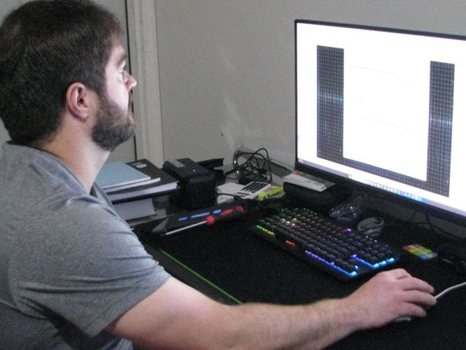 Laser Engraving: Clay Weber controls process with computer.