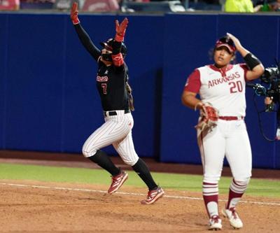 Nebraska's Ava Kuszak (7) celebrates a walk-off home run next to Arkansas' Tianna Bell (20) in the tenth inning during a Women's College World Series softball game between the Arkansas Razorbacks and the Nebraska Cornhuskers at Devon Park in Oklahoma Ci...