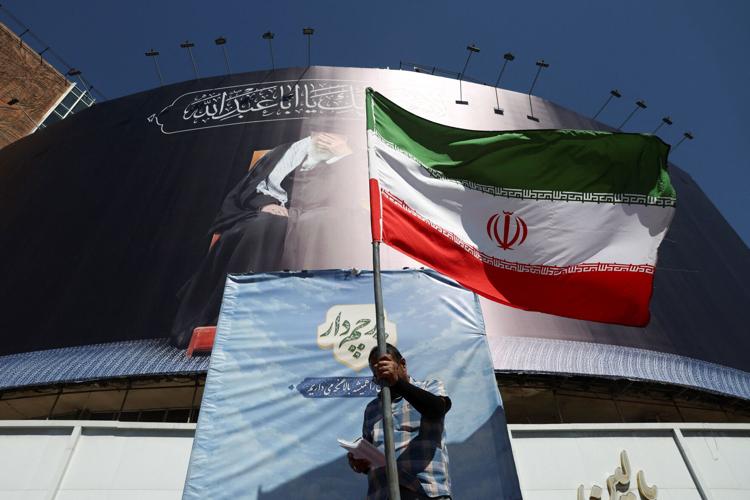 A man holds an Iranian flag on a street, in Tehran