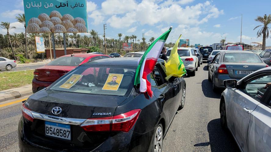 A car with an Iranian flag fluttering outside its window while in traffic, as people head further south following the deal between the U.S. and Iran, in Sidon
