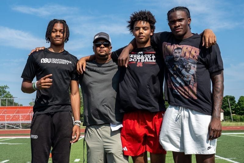 From left to right, Donald Tabron II, 16, Donovan Dooley, 40, owner and founder of Quarterback University, Trae Taylor, 16, and Bryce Underwood, 17, take a photo together after participating in a private workout in Detroit on Saturday, June 21, 2025.