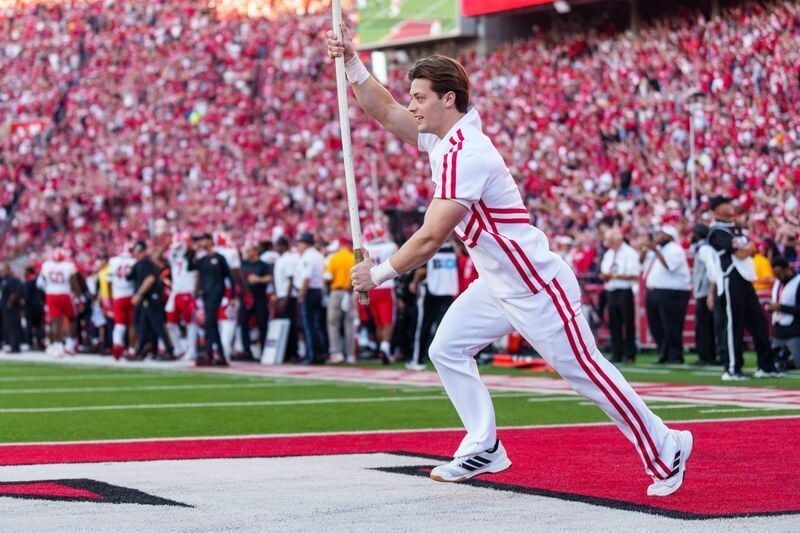 Oct 3, 2026; Lincoln, Nebraska, USA;  A Nebraska Cornhuskers cheerleader runs with a flag on the field after a score against the Maryland Terrapins during the fourth quarter at Memorial Stadium.  Mandatory Credit: Dylan Widger-Imagn Images