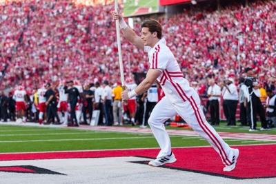 Oct 3, 2026; Lincoln, Nebraska, USA;  A Nebraska Cornhuskers cheerleader runs with a flag on the field after a score against the Maryland Terrapins during the fourth quarter at Memorial Stadium.  Mandatory Credit: Dylan Widger-Imagn Images