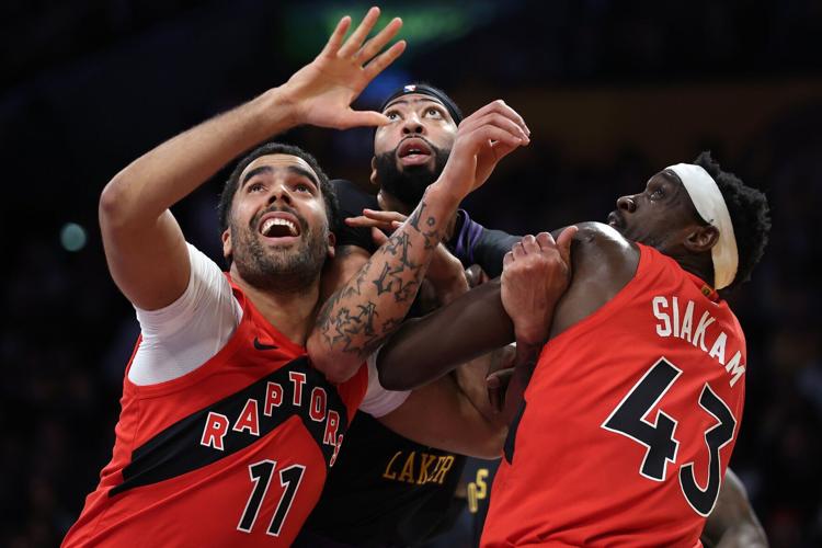 The Toronto Raptors' Jontay Porter and Pascal Siakam lean on the Los Angeles Lakers' Anthony Davis during the first half at Crypto.com Arena on Jan. 9, 2024, in Los Angeles.