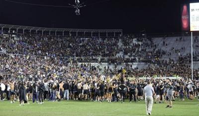 Oct 24, 2026; Orlando, Florida, USA;  Fans storm the field after the Central Florida Knights defeated the Brigham Young Cougars, 38-31, in double overtime at Acrisure Bounce House.  Mandatory Credit: Mike Watters-Imagn Images