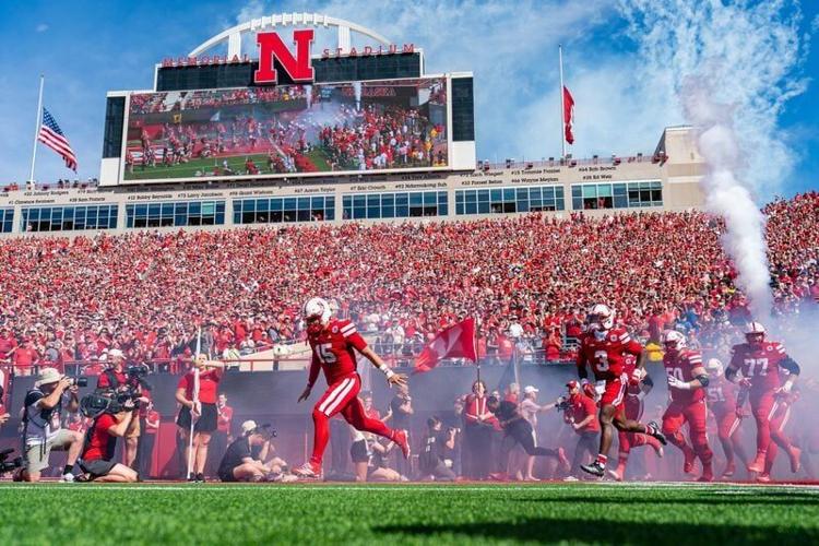 Sep 13, 2025; Lincoln, Nebraska, USA; The Nebraska Cornhuskers run onto the field before the game against the Houston Christian Huskies at Memorial Stadium. Mandatory Credit: Dylan Widger-Imagn Images