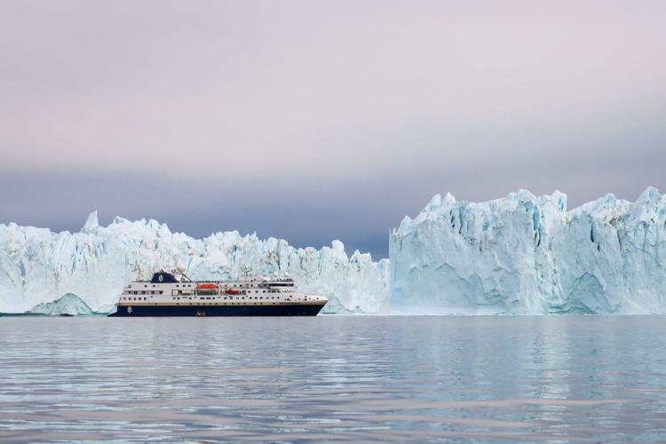 The MS Spitsbergen passing a vast iceberg off Greenland.