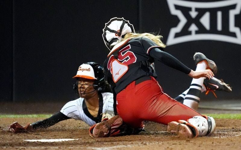 Oklahoma State's Kaya Booker (99) is tagged out at home by Nebraska's Jesse Farrell (25) in the seventh inning during the college softball game between the Oklahoma State University Cowgirls and the Nebraska Cornhuskers in Stillwater, Okla., Thursday Fe...