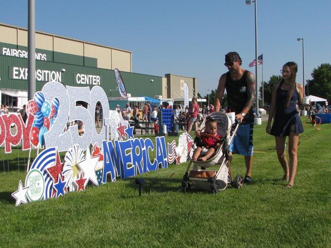 America 250 -- Cory Flaig and Shailey Smith stroll through the America 250 Independence Day celebration with Tripp Flaig, 1, at the Buffalo County Fairgrounds Saturday evening..JPG