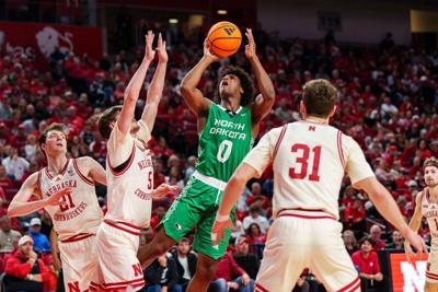 Dec 21, 2025; Lincoln, Nebraska, USA; North Dakota Fighting Hawks forward Marley Curtis (0) shoots the ball against Nebraska Cornhuskers forward Braden Frager (5), forward Pryce Sandfort (21) and guard Cale Jacobsen (31) during the second half at Pinnac...