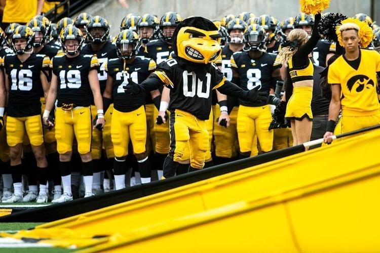 Iowa Hawkeyes players hold hands as they get ready to swarm onto the field with the University of Iowa mascot Herky the Hawk before an NCAA Big Ten Conference football game against Indiana, Saturday, Sept. 4, 2021, at Kinnick Stadium in Iowa City, Iowa....