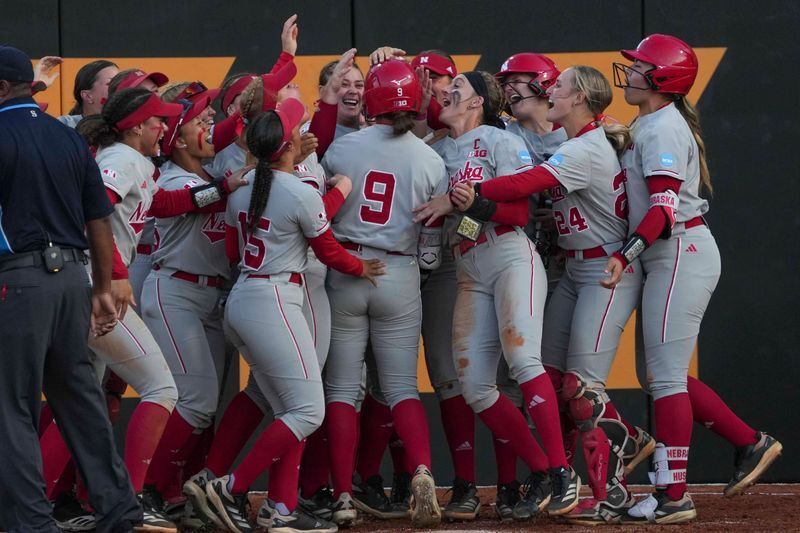 Nebraska's Hannah Camenzind (9) celebrates with teammates after hitting a home run during a NCAA super regional game between Tennessee and Nebraska at Sherri Parker Lee Stadium in Knoxville, Tenn., on May 23, 2025.