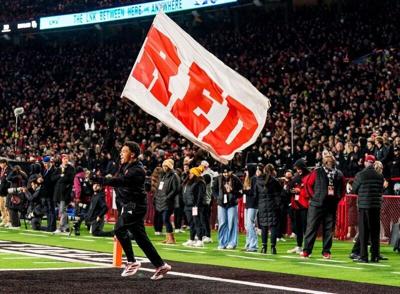 Nov 1, 2025; Lincoln, Nebraska, USA; A Nebraska Cornhuskers cheerleader carries a flag across the field after a score against the Southern California Trojans during the fourth quarter at Memorial Stadium. Mandatory Credit: Dylan Widger-Imagn Images