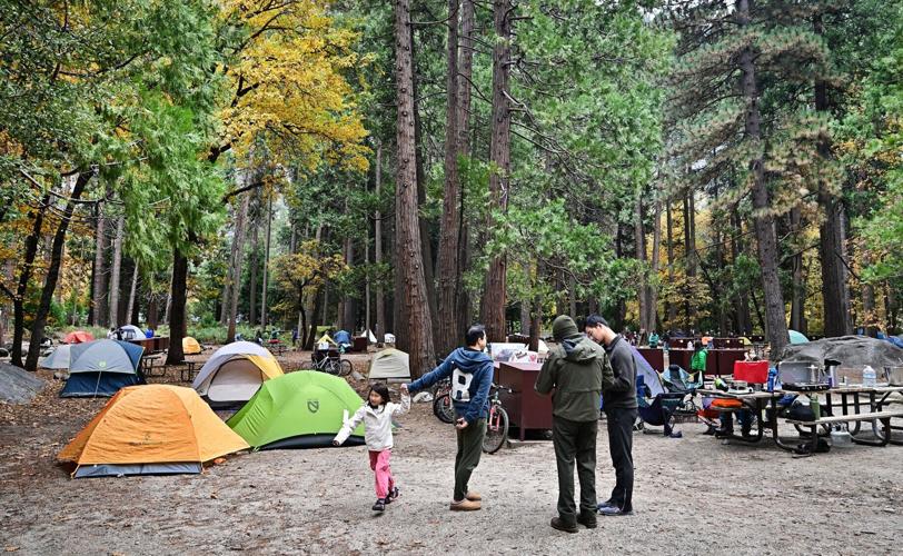 People walk through tents at Yosemite Valley campground in Yosemite National Park, California on Oct. 25, 2025.