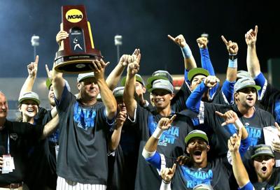 UCLA head coach John Savage holds up the championship trophy after defeating Mississippi State during the College World Series on June 25, 2013, at TD Ameritrade Park in Omaha, Nebraska.