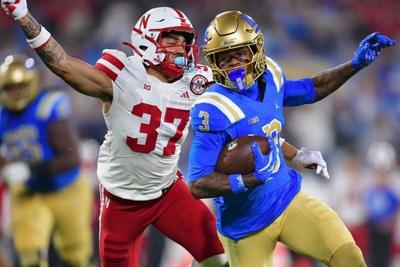 Nov 8, 2025; Pasadena, California, USA; UCLA Bruins wide receiver Kwazi Gilmer (3) runs the ball ahead of Nebraska Cornhuskers defensive back Donovan Jones (37) during the first half at the Rose Bowl. Mandatory Credit: Gary A. Vasquez-Imagn Images