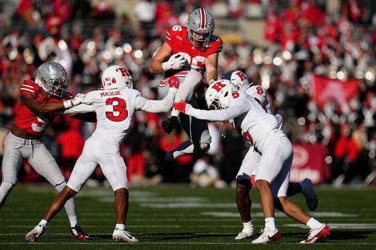 Ohio State Buckeyes tight end Max Klare (86) hurdles Rutgers Scarlet Knights defensive back Bo Mascoe (3), defensive back Kaj Sanders (5) and linebacker Dariel Djabome (8) during the second half of the NCAA football game at Ohio Stadium in Columbus on N...