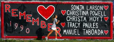 A University of Florida student jogs past a graffiti painted wall on 34th street in Gainesville, Florida, on Oct. 26, 2006.