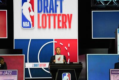 NBA deputy commissioner Mark Tatum holds a sign for the Miami Heat during the 2026 NBA Draft Lottery at Navy Pier.
