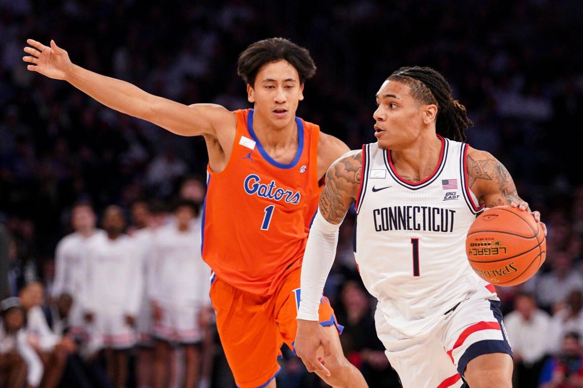 Connecticut's Solo Ball, right, drives against Florida's Xaivian Lee in the first half at Madison Square Garden on Tuesday, Dec. 9, 2025, in New York.