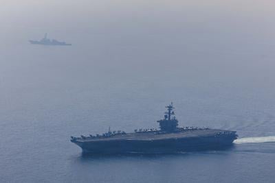 In this handout photo obtained from the U.S. Defense Department, Nimitz-class aircraft carrier USS Abraham Lincoln and Arleigh Burke- class guided-missile destroyer USS Frank E. Petersen Jr. sail in the Arabian Sea, Feb. 6, 2026.