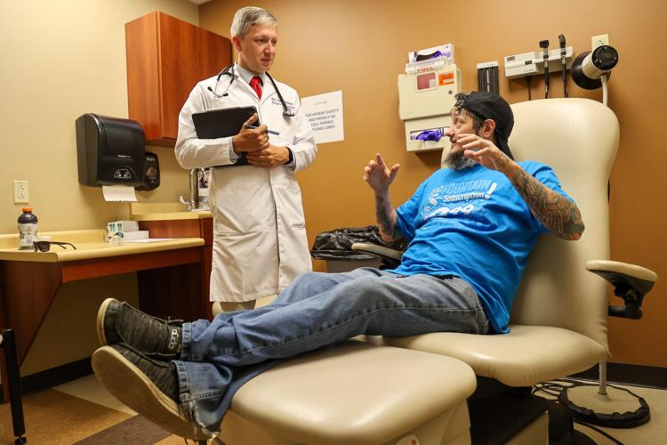 Patient Denver Feltner talks with a physician at the Primary Care Centers of Eastern Kentucky clinic in Perry County, Kentucky.