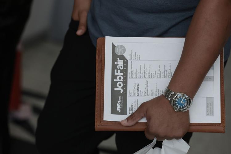A job seeker holds paperwork during the Mega JobNewsUSA South Florida Job Fair held in the Amerant Bank Arena on Sept. 25, 2026, in Sunrise, Fla. Hiring managers and recruiters from more than 50 companies attended the job fair to recruit workers for opp...