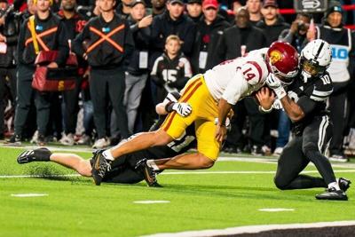 Nov 1, 2025; Lincoln, Nebraska, USA; Southern California Trojans quarterback Jayden Maiava (14) is tackled by Nebraska Cornhuskers defensive back Rex Guthrie (21) and defensive back Andrew Marshall (10) during the second quarter at Memorial Stadium. Man...