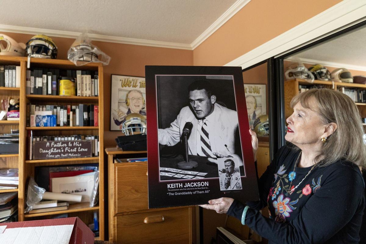 Melanie Jackson, daughter of iconic college football broadcaster Keith Jackson, holds up a photo of the iconic broadcaster at his one-time home on Thursday, Jan. 1, 2026, in the Sherman Oaks neighborhood of Los Angeles.