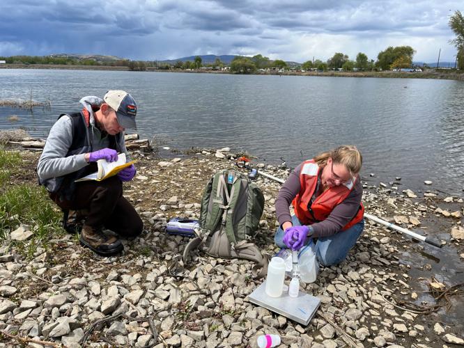 Jacob Carnes (left) and Lili White of the Washington Department of Ecology collect water samples from a pond near the Army's Yakima Training Center. Wells at more than 140 homes nearby have tested over the EPA's drinking water limit for PFAS.