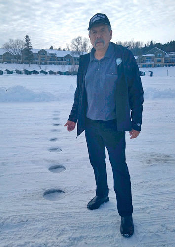 Leech Lake Tribal Chairman Faron Jackson gestures to the nearly 20 holes that were drilled early last Thursday morning along the ice highway from Walker City Park to Onigum on Walker Bay.