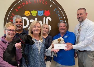 Store Manager Mark McKenna (right) hands a check to Executive Director Shelley Block, who is pictured with staff and volunteers (from left) Jessie Gearns, Mitch Bouchonville, Karen Will and Jay Cline.