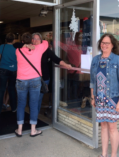 Owner Nancy Freeman gets a big hug from friend, Dawn Anderson, after she opens the door, as staff member Patty Knight looks on. Photos by Melanie Rice, Rice Creative Services, LLC