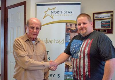 Ken Bresley (left) former owner of Village Homes, Walker, congratulates new owner Russ Rich.