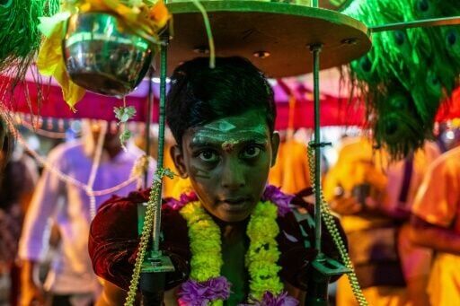 A young Hindu devotee carries "kavadi" on his shoulders as he makes his way towards the Batu Caves temple for the Thaipusam festival