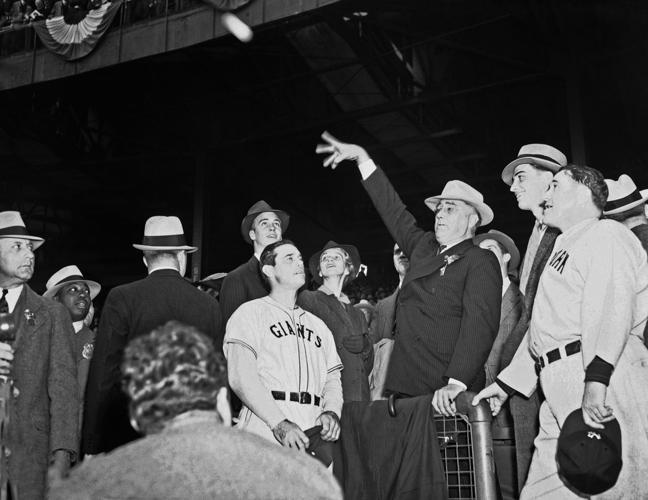 President George H.W.Bush reacts after throwing a one-hopper, the  ceremonial first pitch, to Baltimore Orioles catcher Chris Hoiles to open  Oriole Park at Camden Yards in Baltimore on Monday, April 6, 1992.